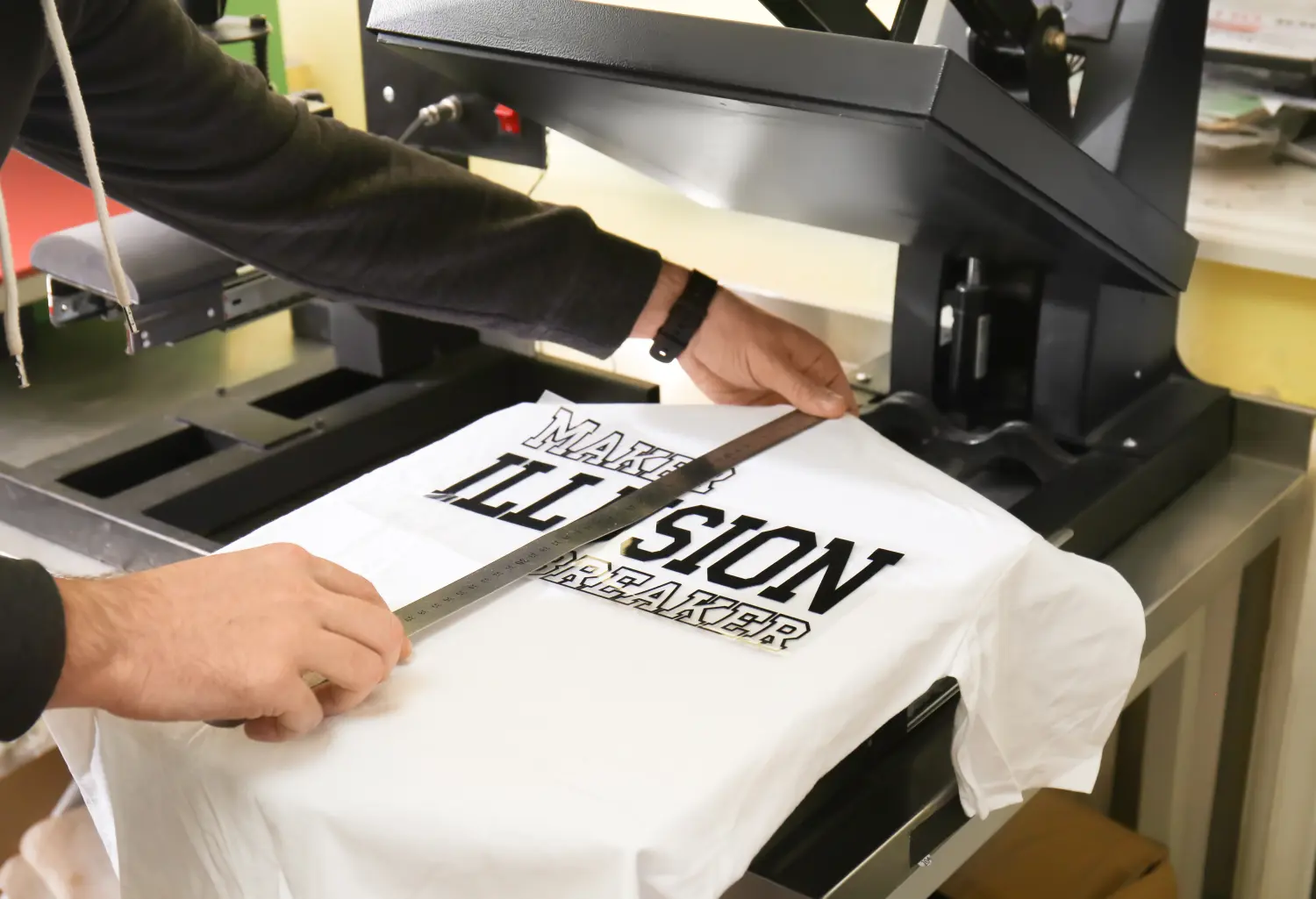 Junger Mann bedruckt T-Shirt in der Werkstatt
