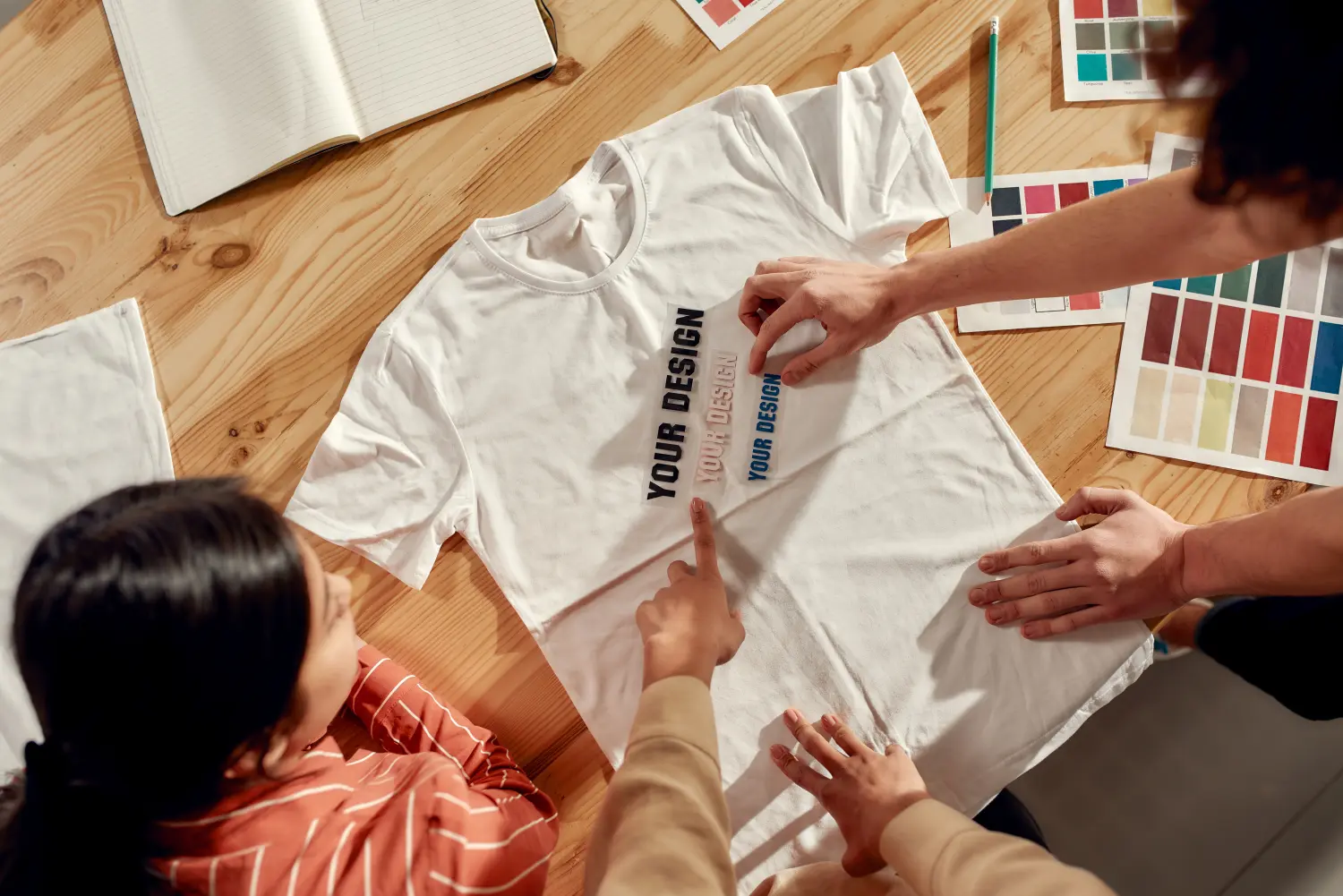 Schreiben, das verkauft. Kreative Menschen probieren Aufkleber mit Text an und diskutieren dabei über Logo und Design des T-Shirts.